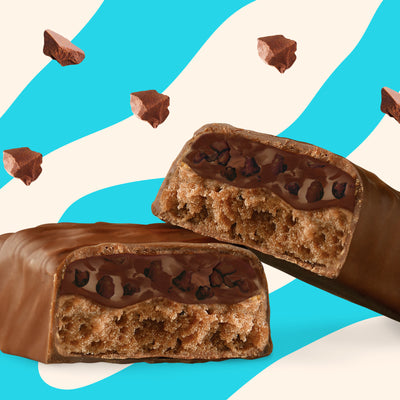 Box of N!CK'S Triple Chocolate Protein Bars (12-pack), with an unwrapped bar showing the interior. Highlights 15g protein and "no added sugar" for a keto-friendly snack.