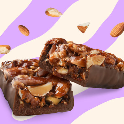 Box of N!CK'S Almond Crunch Nut Bars (12-pack), with a bar unwrapped to show the whole almonds and filling. Highlights "no added sugar" and "100% pleasure."