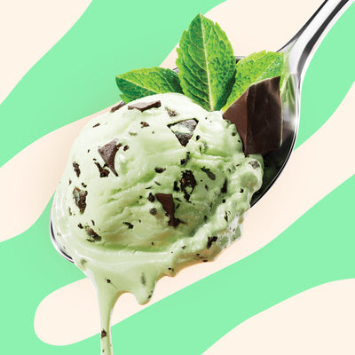Pint of N!CK'S Mint Chocolate Chip light ice cream. The label highlights 'no added sugar' and '340 calories/pint'. A spoon holds a scoop of mint green ice cream with dark chocolate chips and a mint leaf.