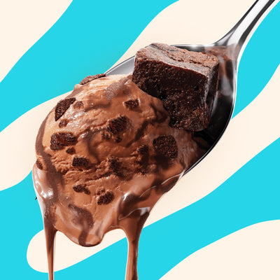 Pint of N!CK'S Triple Chocolate Brownie light ice cream. The label highlights 'no added sugar' and '350 calories/pint'. A spoon holds a scoop of the chocolate ice cream with brownie pieces.