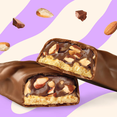 N!CK'S Almond Chocolate Protein Bar, 12-pack box, showing an unwrapped bar with visible almonds and chocolate filling. Highlights 14g protein and "no added sugar."